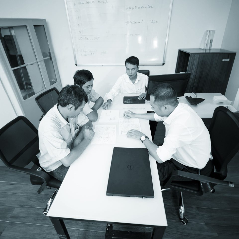 Four colleagues reviewing plans together around a desk